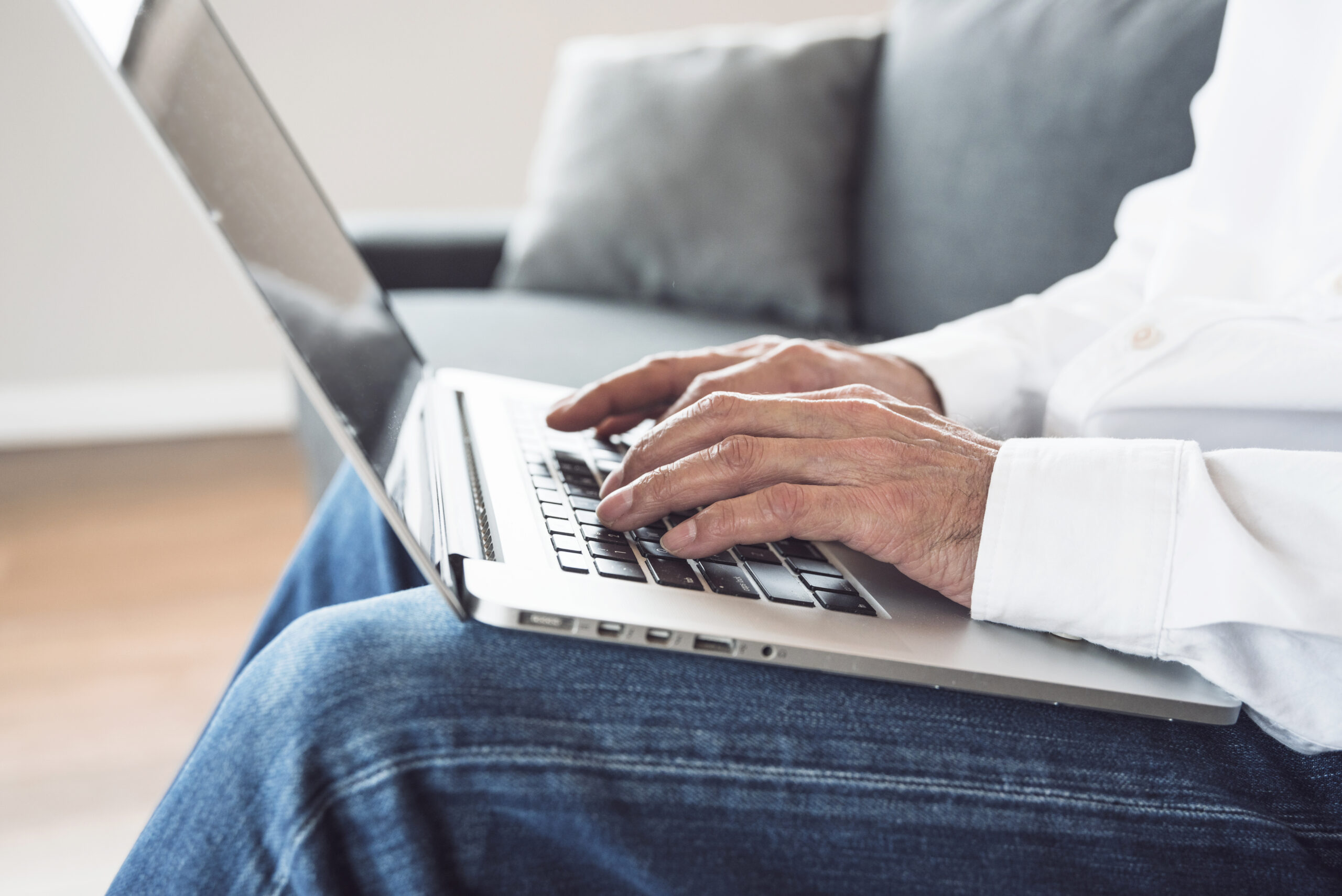 close-up-elderly-man-typing-laptop-scaled